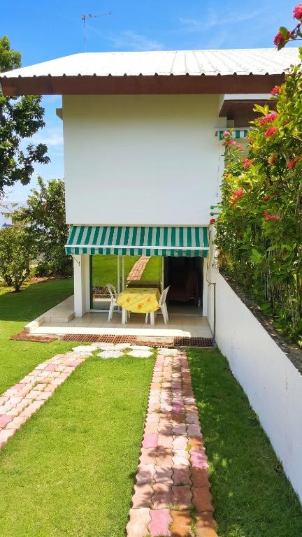 a patio of a house with a bench under a awning at Appartement charmant à Baie Mahault avec belle terrasse – 30 m² in Baie-Mahault