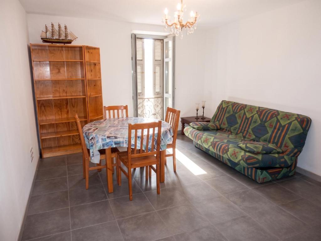 a living room with a table and chairs and a couch at Appartement cosy à Bonifacio avec vue sur la mer - 45 m² in Bonifacio