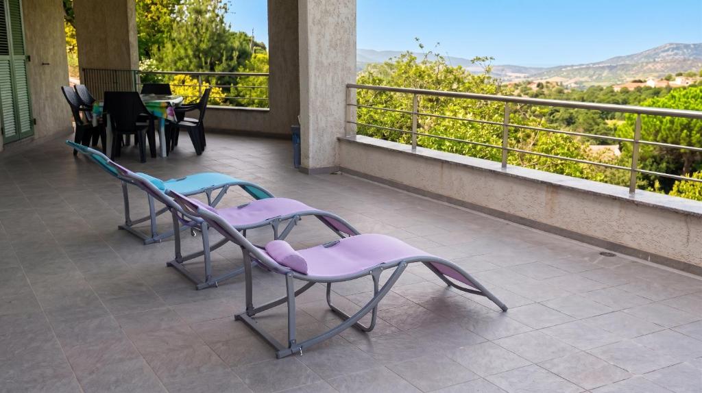 two chairs sitting on a balcony with a view at Maison confortable avec vue sur la mer et la montagne à Oletta. in Oletta