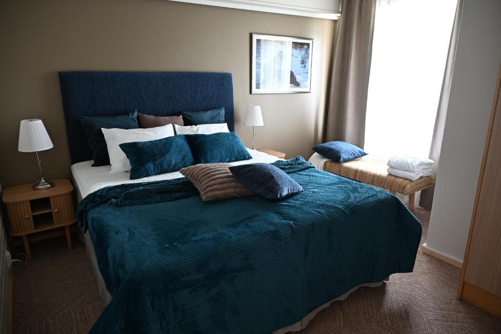 a bedroom with a large bed with blue sheets and pillows at Boutique hotel SAVOIR in Savonlinna