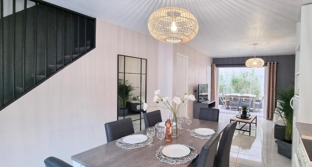 a dining room with a table and chairs at LE BAYARD Authentique Maison Sétoise Patio Climatisée Centre Historique Parking payant à proximité in Sète