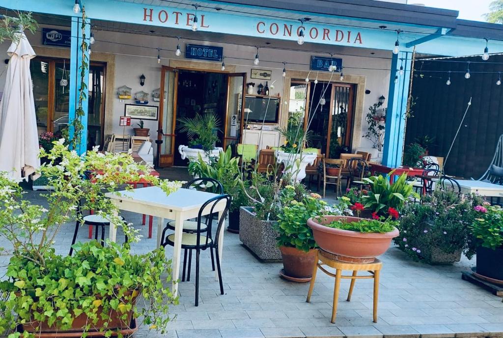 a restaurant with a table and chairs and plants at HOTEL CONCORDIA in Montecatini Terme