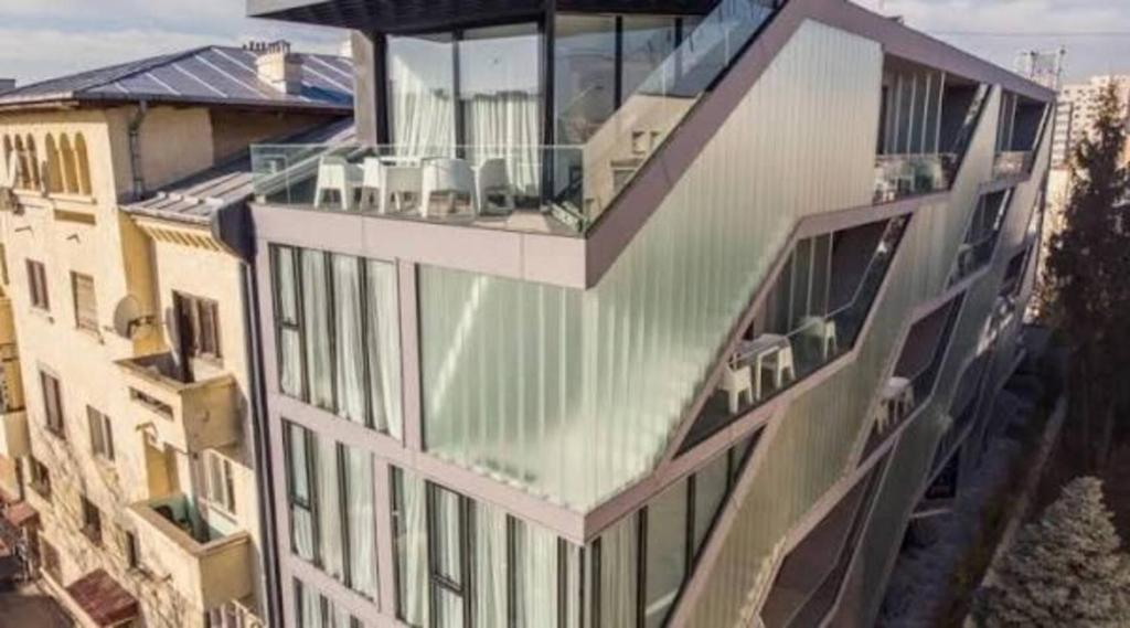 a building with a balcony on top of it at Aparthotel Blend City Center in Bucharest