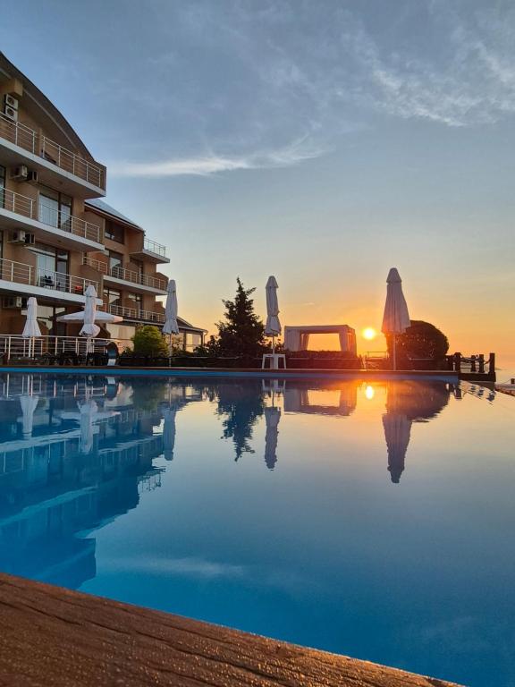 a pool in front of a building with the sunset at Villa Lavanda in Vapnyarka