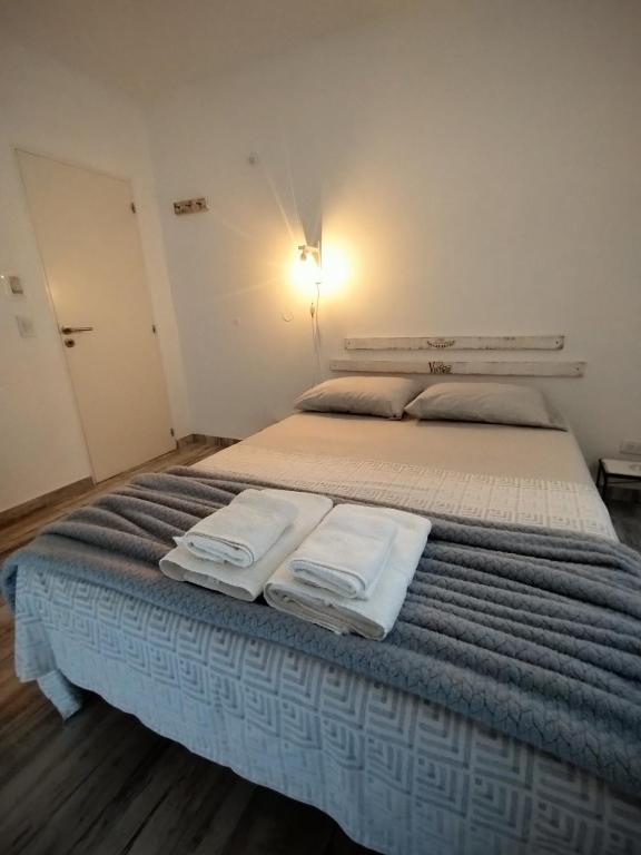 a bedroom with a large bed with towels on it at Casa con jardín Las Marías 1 in Miramar