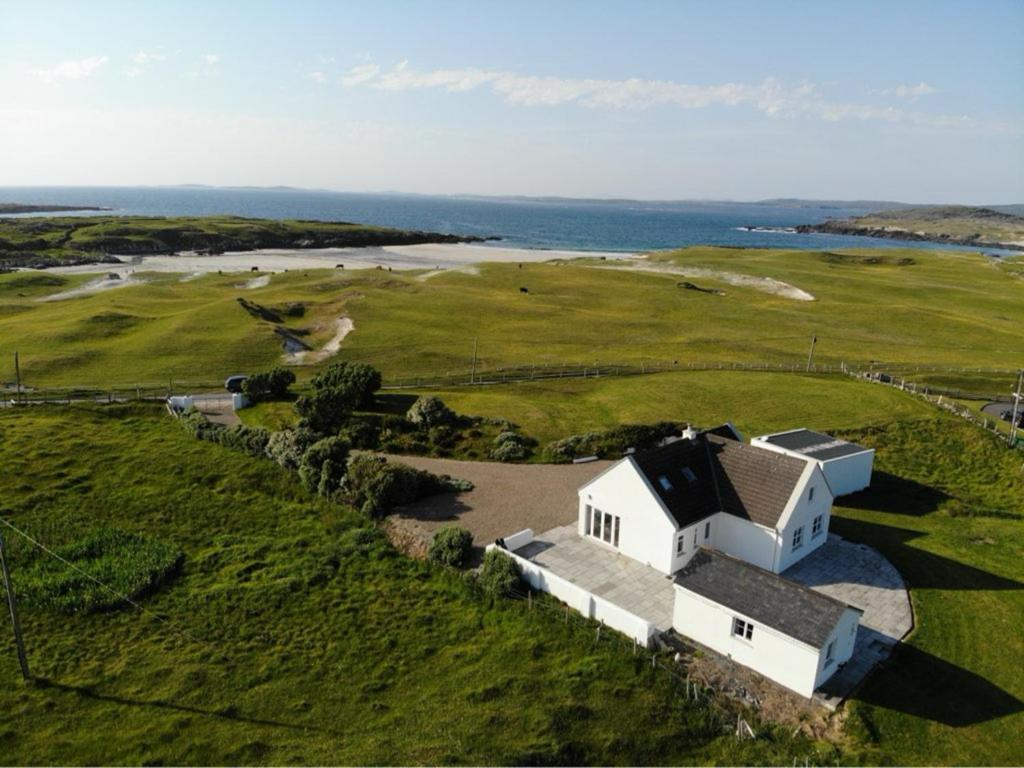 an aerial view of a white house on a golf course at Doonloughan View, Ballyconneely in Ballyconneely