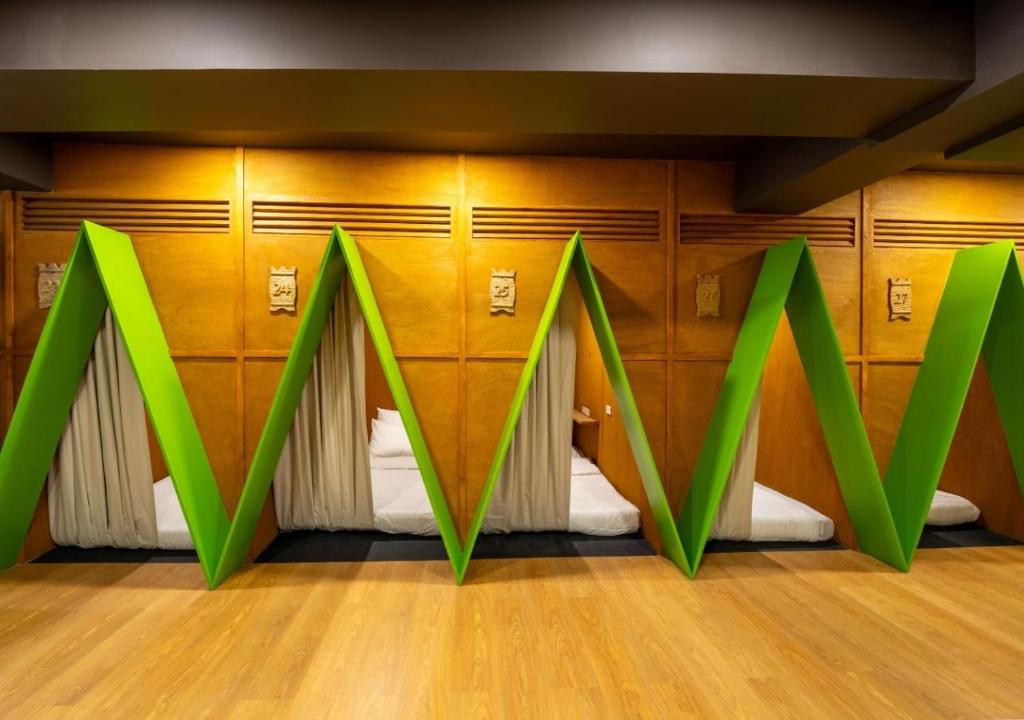 a room with a bed with green arrows on it at 3BU Hostel Baguio - Bonifacio in Baguio