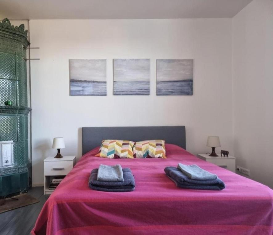 a bedroom with a large pink bed with two pillows at Pispalan Helmi - Koti Näköalalla in Tampere