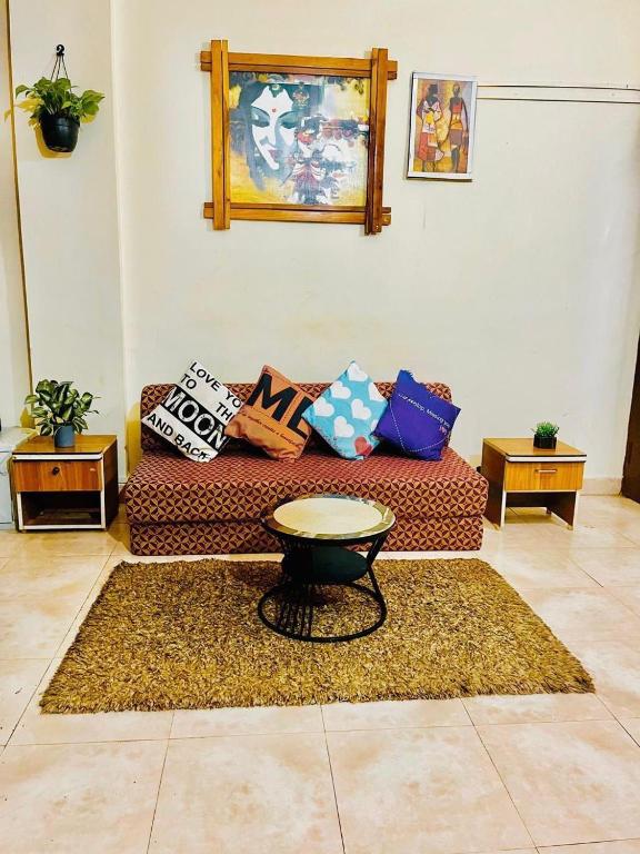 a living room with a couch and a table on a rug at Shiva Valley Retreat in Calangute