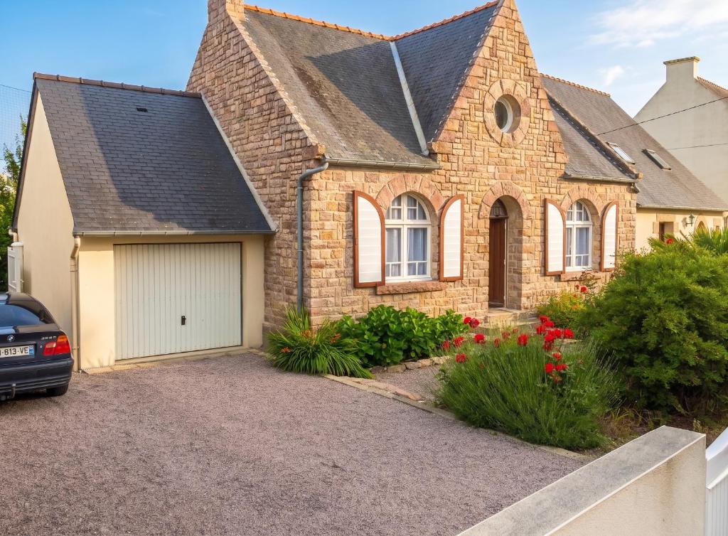 a brick house with a garage in a driveway at Maison chaleureuse à Erquy avec jardin et parking in Erquy