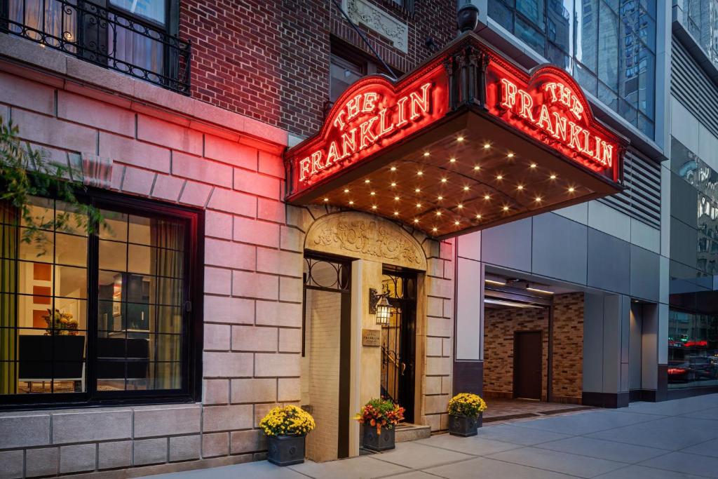 a restaurant with a neon sign on the side of a building at voco The Franklin New York by IHG in New York