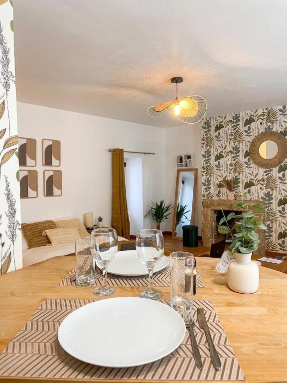 a table with a plate and wine glasses on it at Cozy & Stylish, hyper center in Quimper