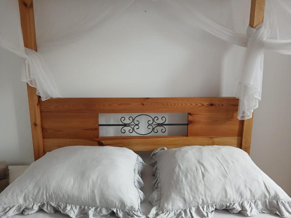 two white pillows sitting on top of a bed at Apartament Biała Przystań in Nowy Sącz