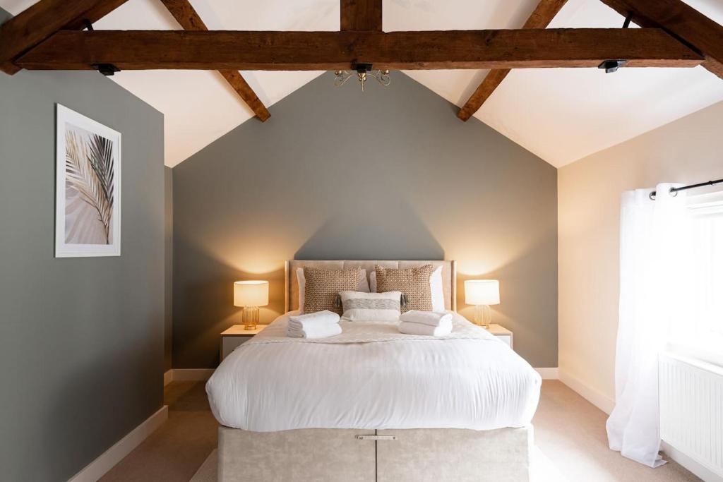 a bedroom with a large white bed with two lamps at Super Central - Quiet - 2 Bedroom Cottage in Shrewsbury