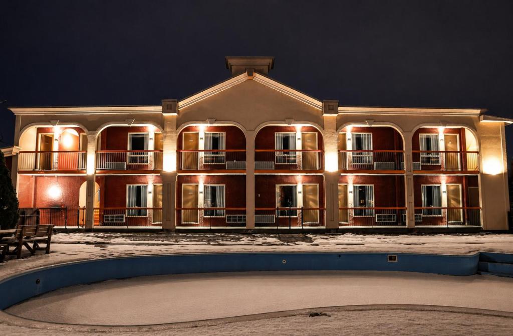 a large building with a pool in front of it at Motel Classique in Joliette