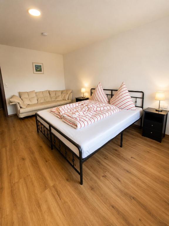 a large bed in a room with a couch at Ferienwohnung Maison Maurus nahe Idar-Oberstein in Mörschied