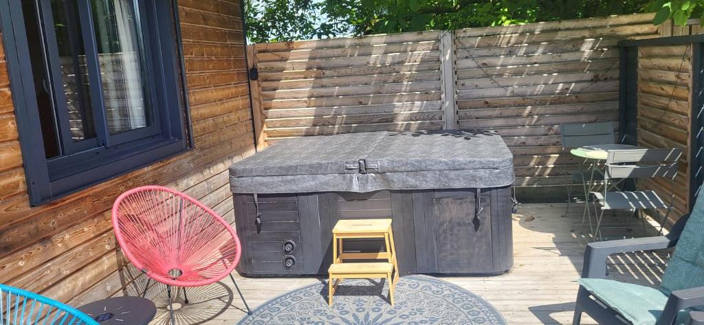 a patio with a grill and a chair and a table at Ty KamBreiz in La Fresnais