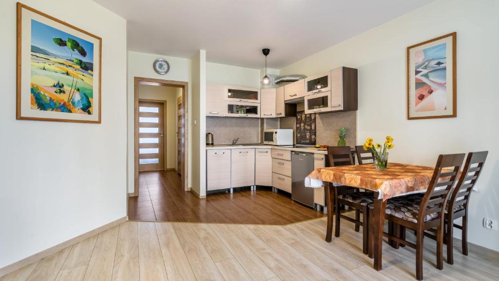 a kitchen and dining room with a table and chairs at Osiedle Bursztynowe in Jantar