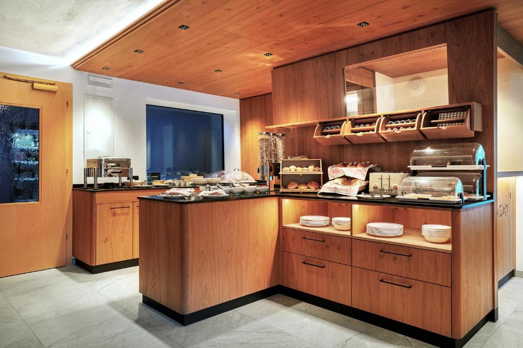 a large kitchen with wooden cabinets and a counter top at Hotel Garni Morene in Selva di Val Gardena