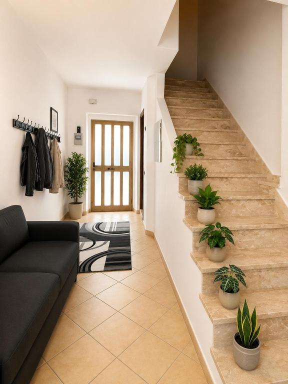 a living room with a staircase with potted plants at Appartamento Martina in Lanusei