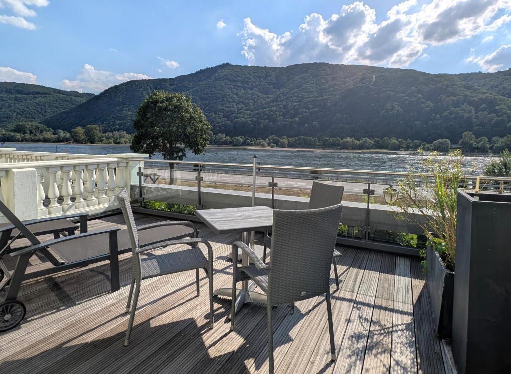 un balcone con tavolo e sedie e vista sul fiume di Hotel Schön am Rhein a Rüdesheim am Rhein