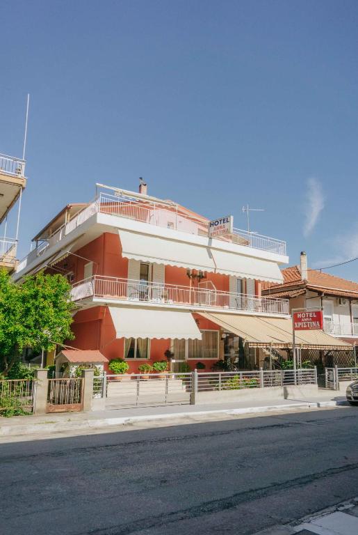 a red and white building on the side of a street at Anna Christina in Kamena Vourla