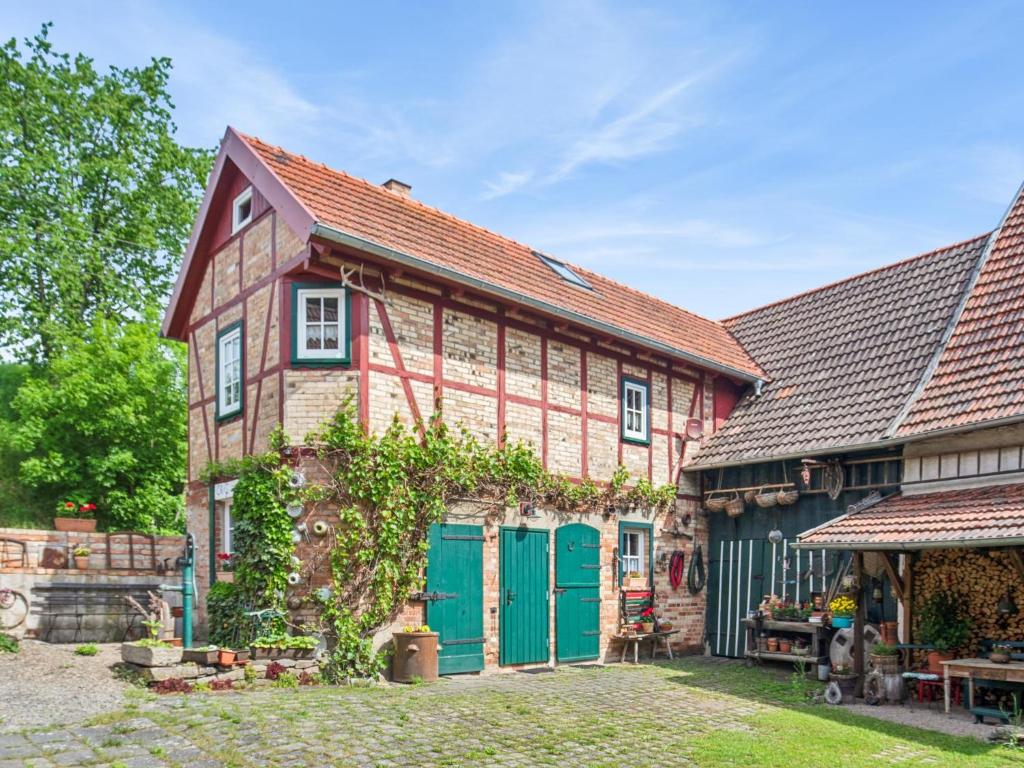 an old house with green doors in a yard at Die Obermühle in Sangerhausen
