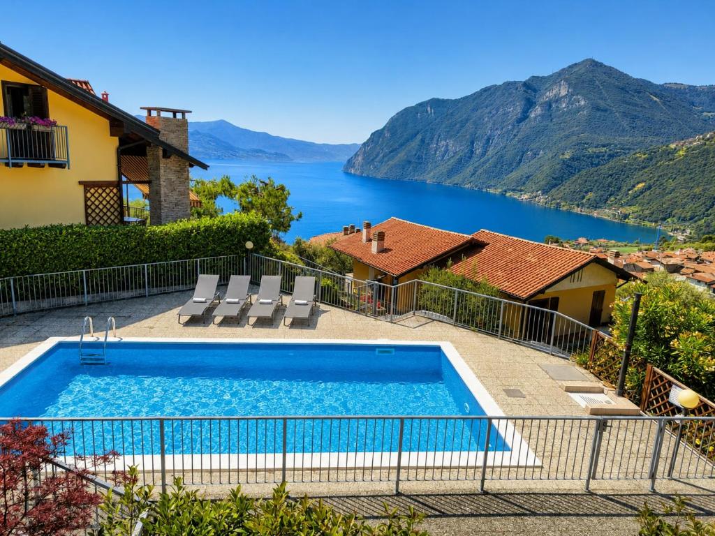 a house with a swimming pool with a view of a lake at Happy Guest Apartments - Lake Panorama & Pool in Riva di Solto