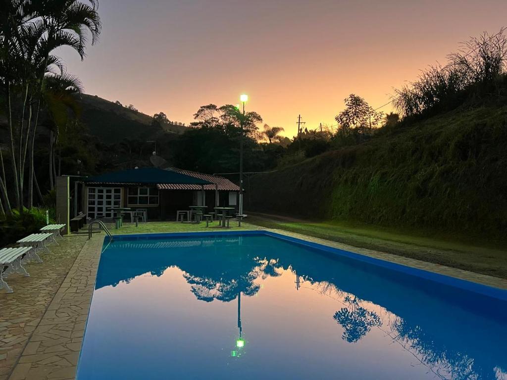 a swimming pool with the reflection of a house at Chalés Talismã in Caconde