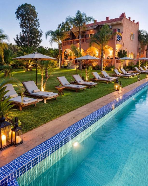 a hotel pool with lounge chairs and a resort at Ferme Oasis de Fes in Fez