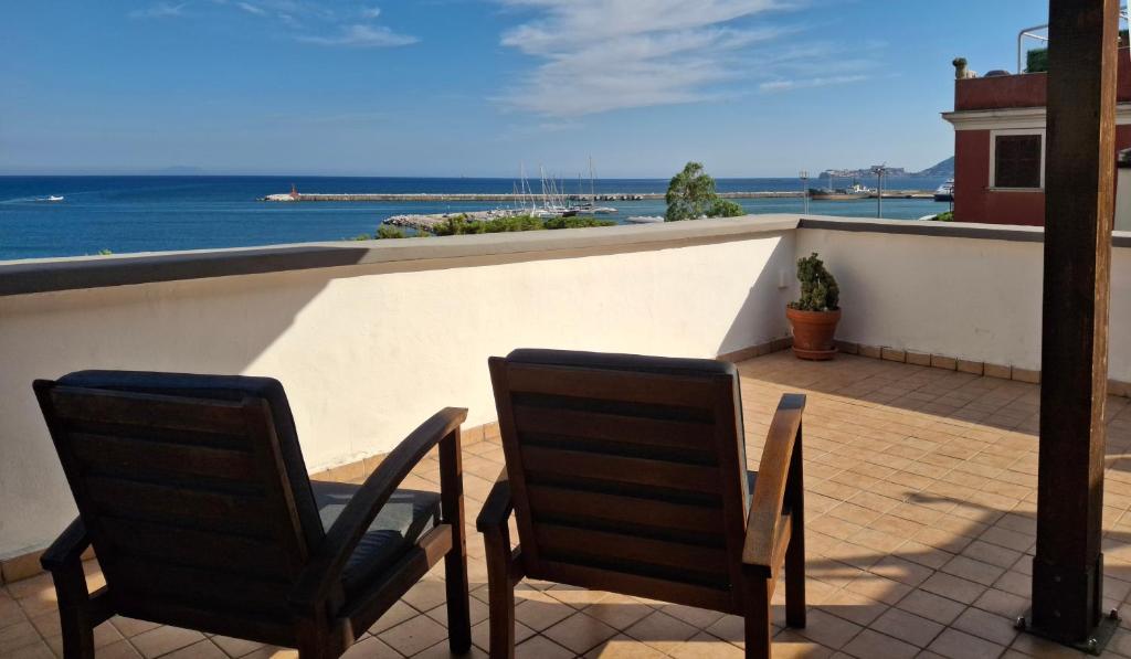two chairs on a balcony with a view of the ocean at Terrazza Tosti in Formia