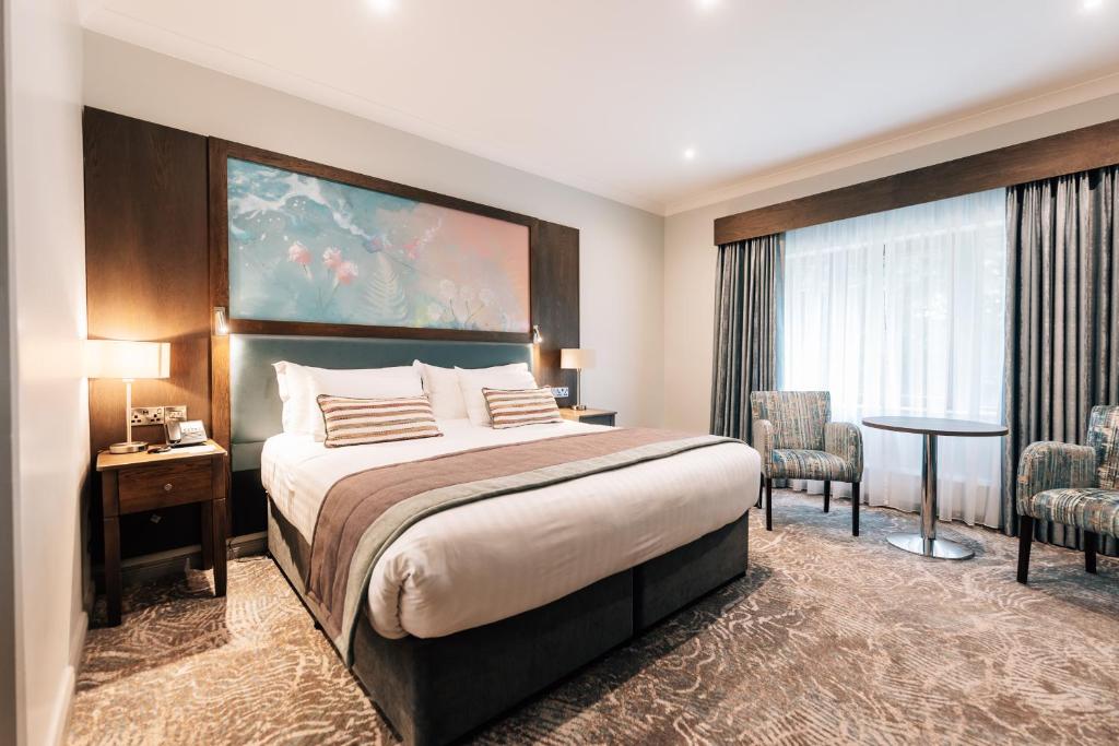 a hotel room with a large bed and a table and chairs at The Lodge Hotel in Coleraine