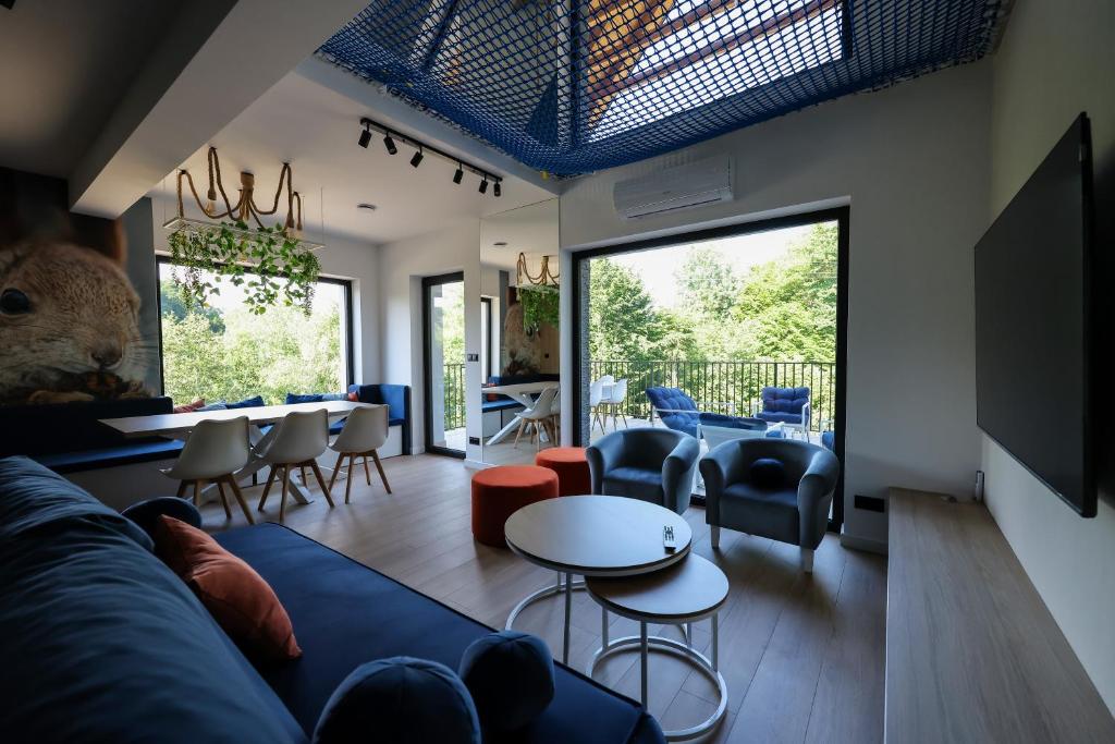 a living room with a blue couch and chairs at Prime - Event & Relax Resort in Jaszczurowa