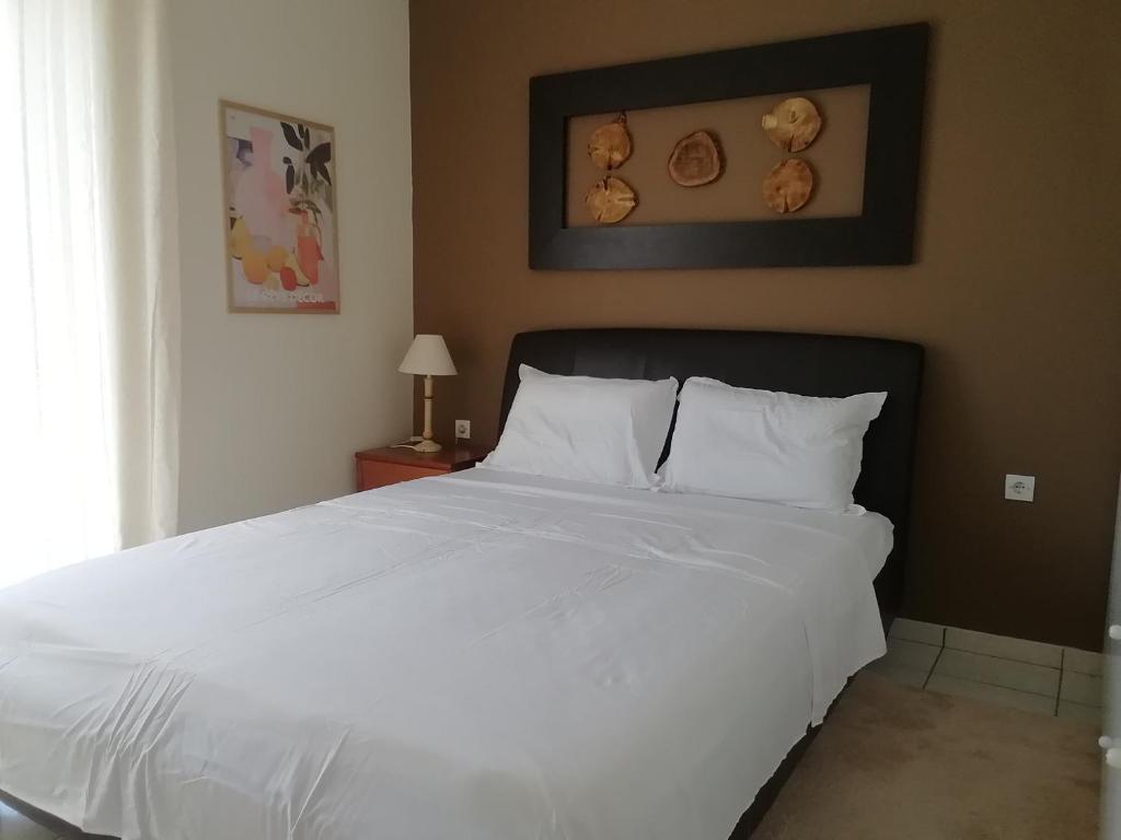 a bedroom with a large white bed and a window at La petite maison in Xiropigado