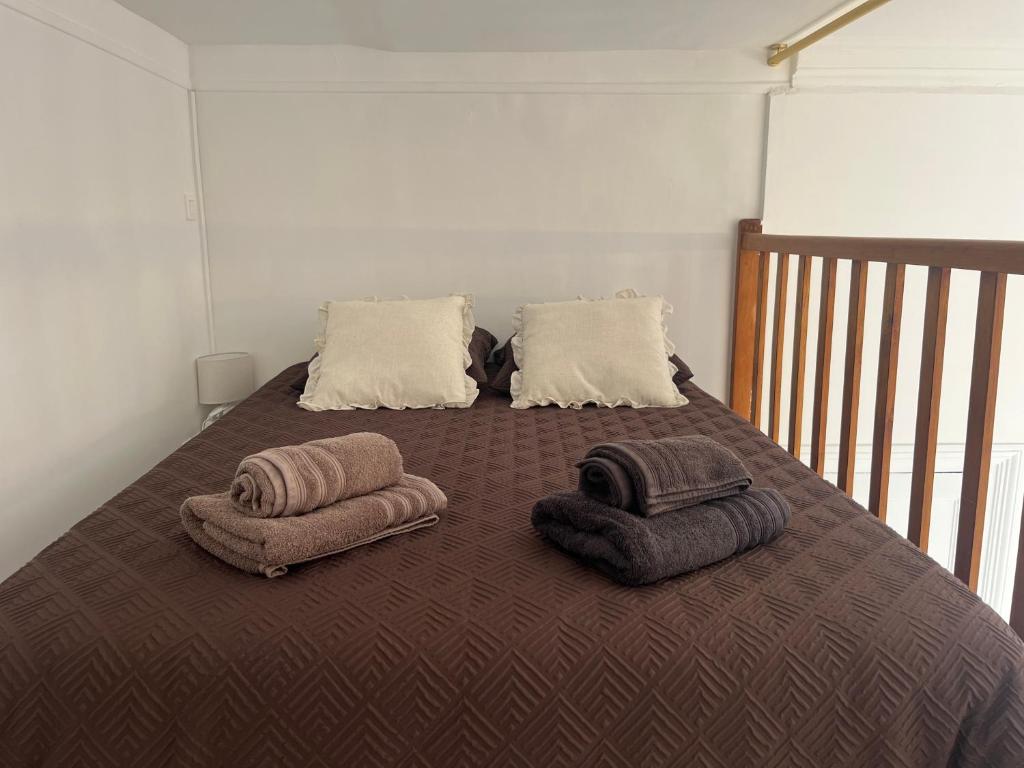 a bed with two blankets and pillows on it at Le Cantilien Apartment - Chantilly in Chantilly