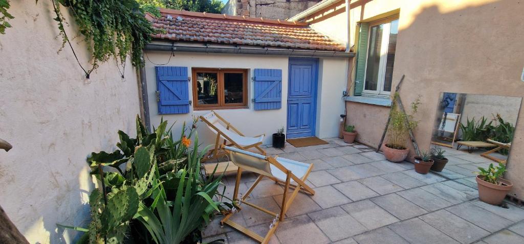 a patio with two chairs and a blue door at La Casita in Avignon