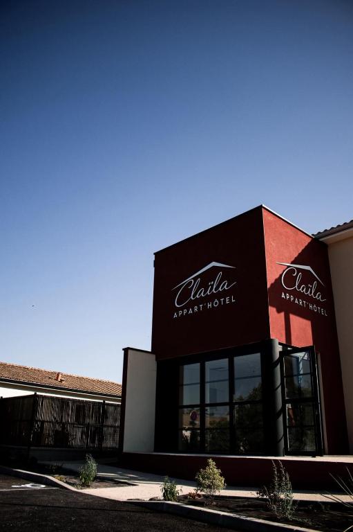 a building with a coca cola sign on it at Claïla Appart-Hôtel Abzac in Abzac