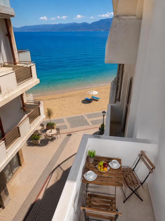 a balcony with a table and a view of the beach at Makas Beachfront Suites Hersonissos Center in Hersonissos