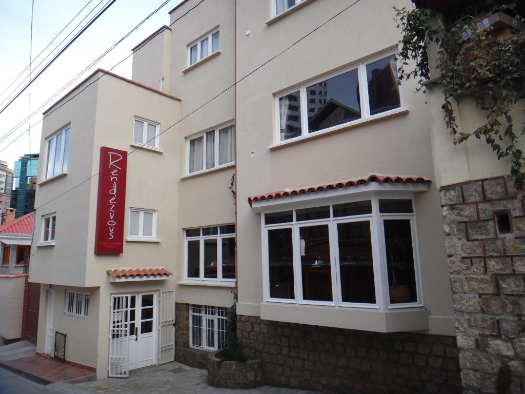 un bâtiment avec un panneau rouge sur son côté dans l'établissement Rendezvous Hostal, à La Paz