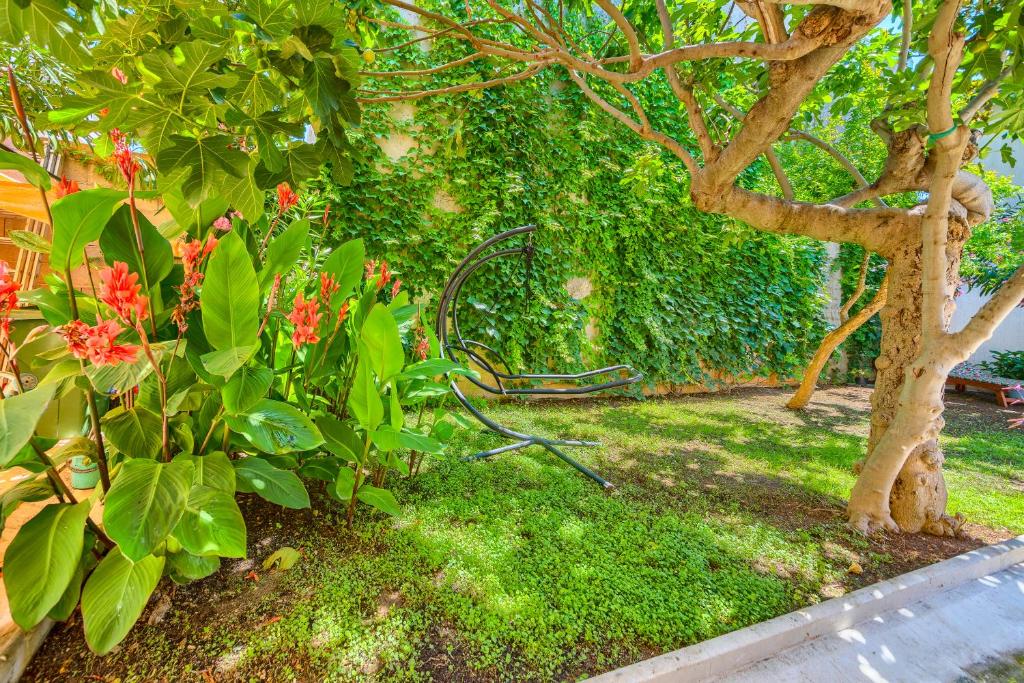 a garden with a bench next to a tree at Garden House Vodice in Vodice