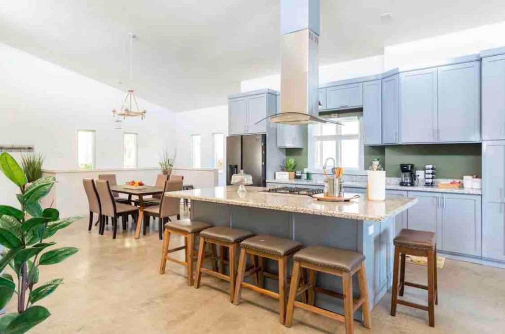 a kitchen with white cabinets and a large island with bar stools at La Casa Del Valle in Francisco Zarco