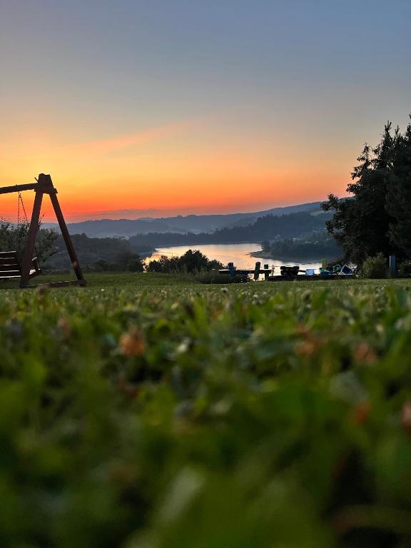 a view of a field with a sunset in the background at Brzozowe Wzgórze in Wołkowyja