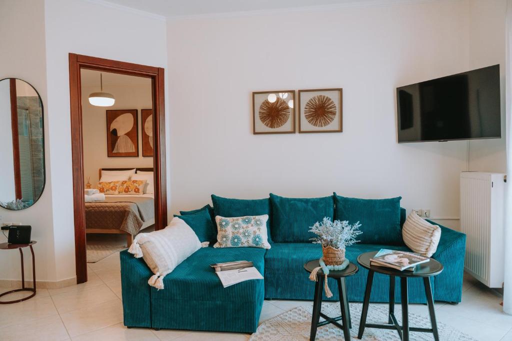 a living room with a blue couch and a tv at Tina's Resident in Igoumenitsa