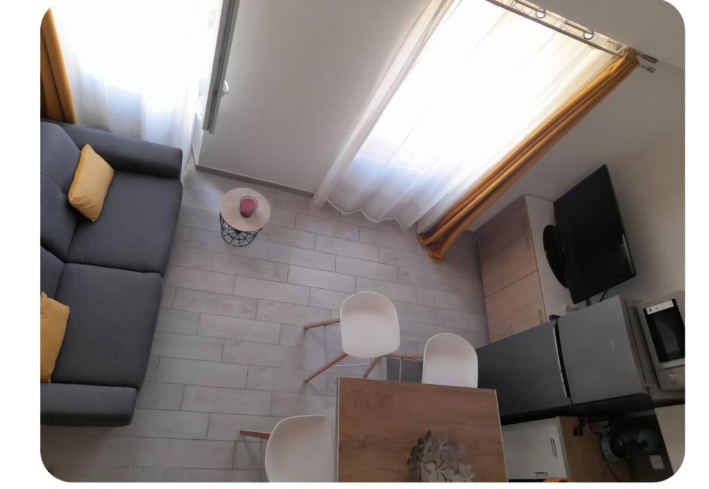 a small living room with a couch and a tv at Duplex centre historique frejus in Fréjus