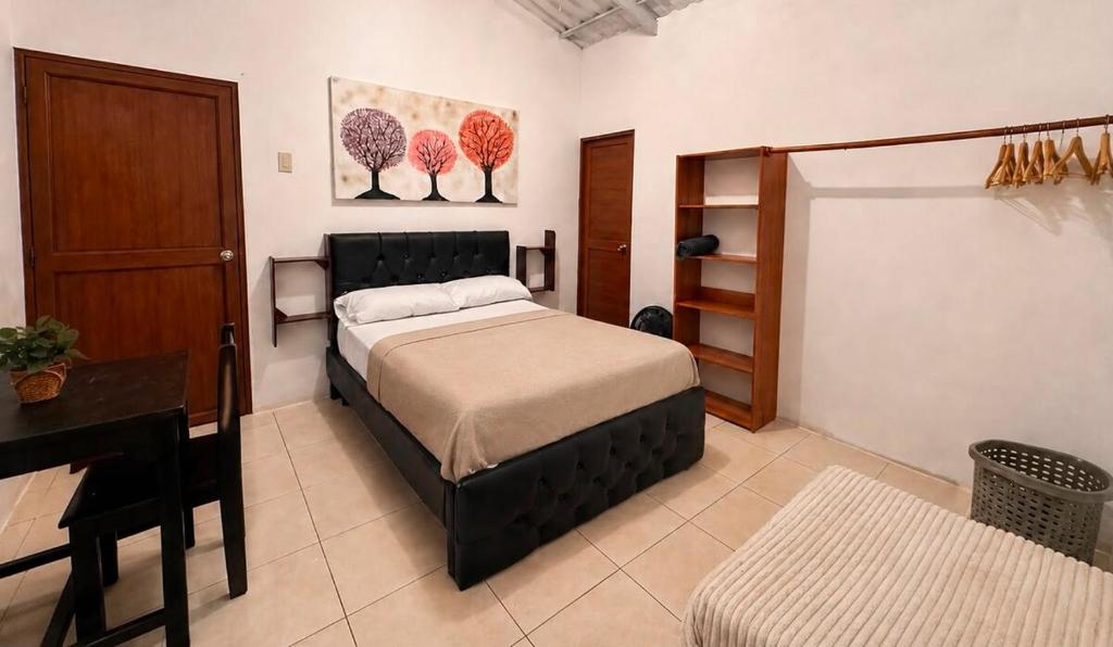 a bedroom with a bed and a table and a desk at Hospedaje Isabela in Puerto Villamil