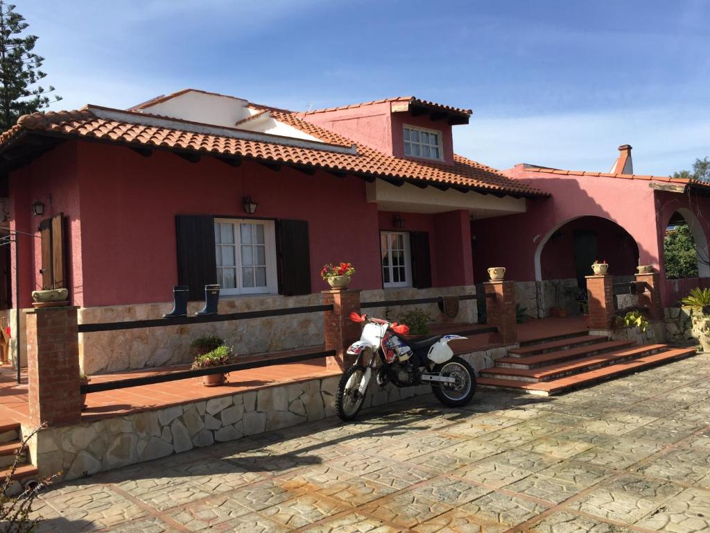 奧古斯塔的住宿－Villa Angela，停在红房子前面的摩托车
