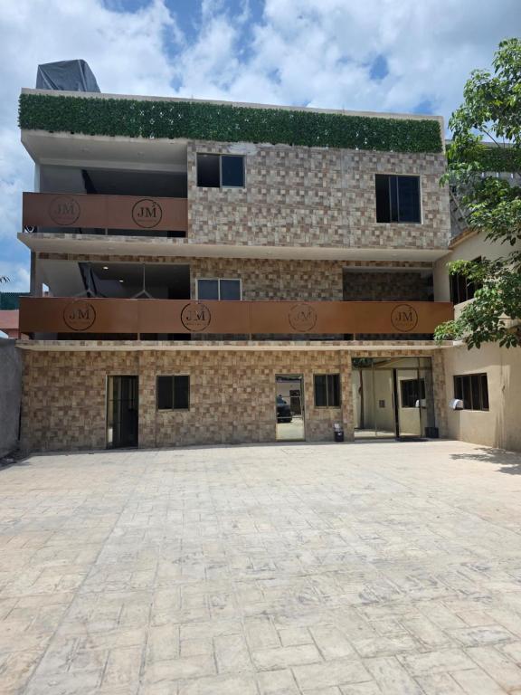 ein großes Gebäude mit einer davorliegenden steinernen Auffahrt in der Unterkunft Hotel & Suites JM in Orizatlán