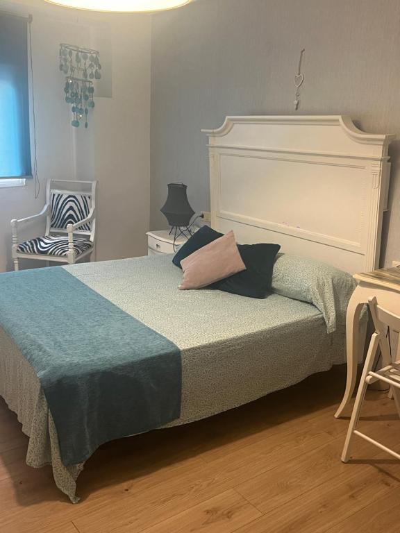 a bedroom with a large bed and a chair at CENTRO HISTORICO in Manzanares