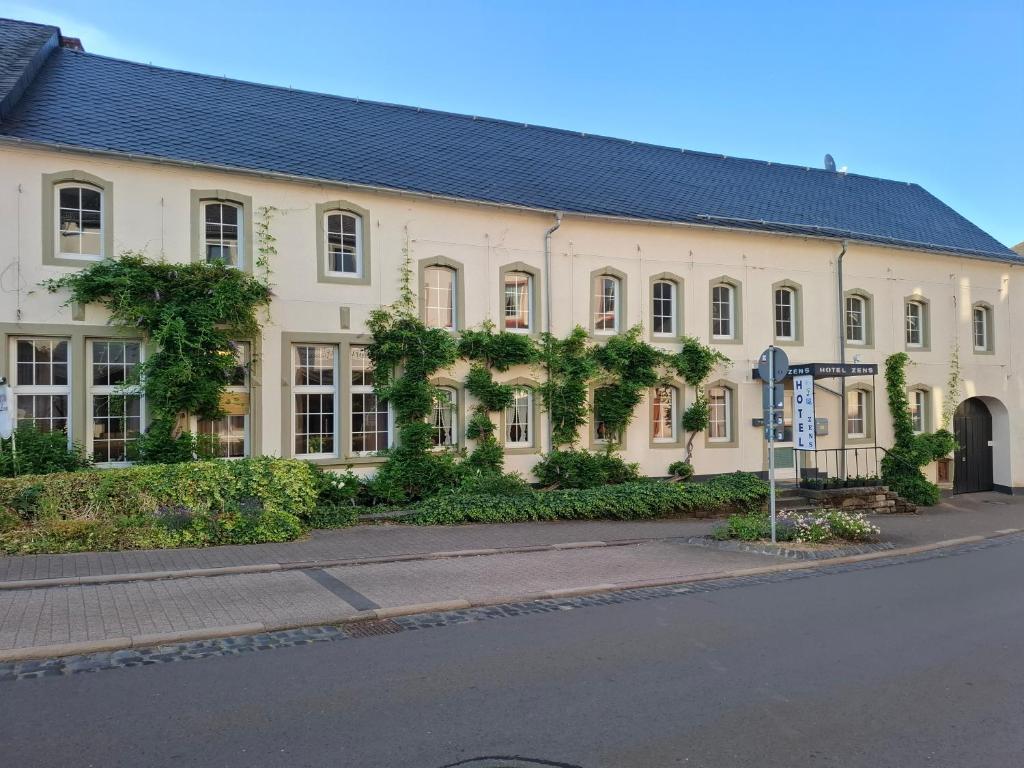 a large white building with a street in front of it at Hotel Zens in Manderscheid