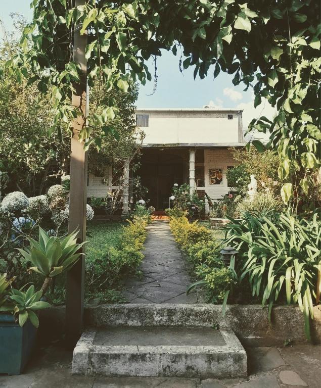 a garden with a pathway leading to a building at GuacamayaGuestHouse in Concepción de Ataco